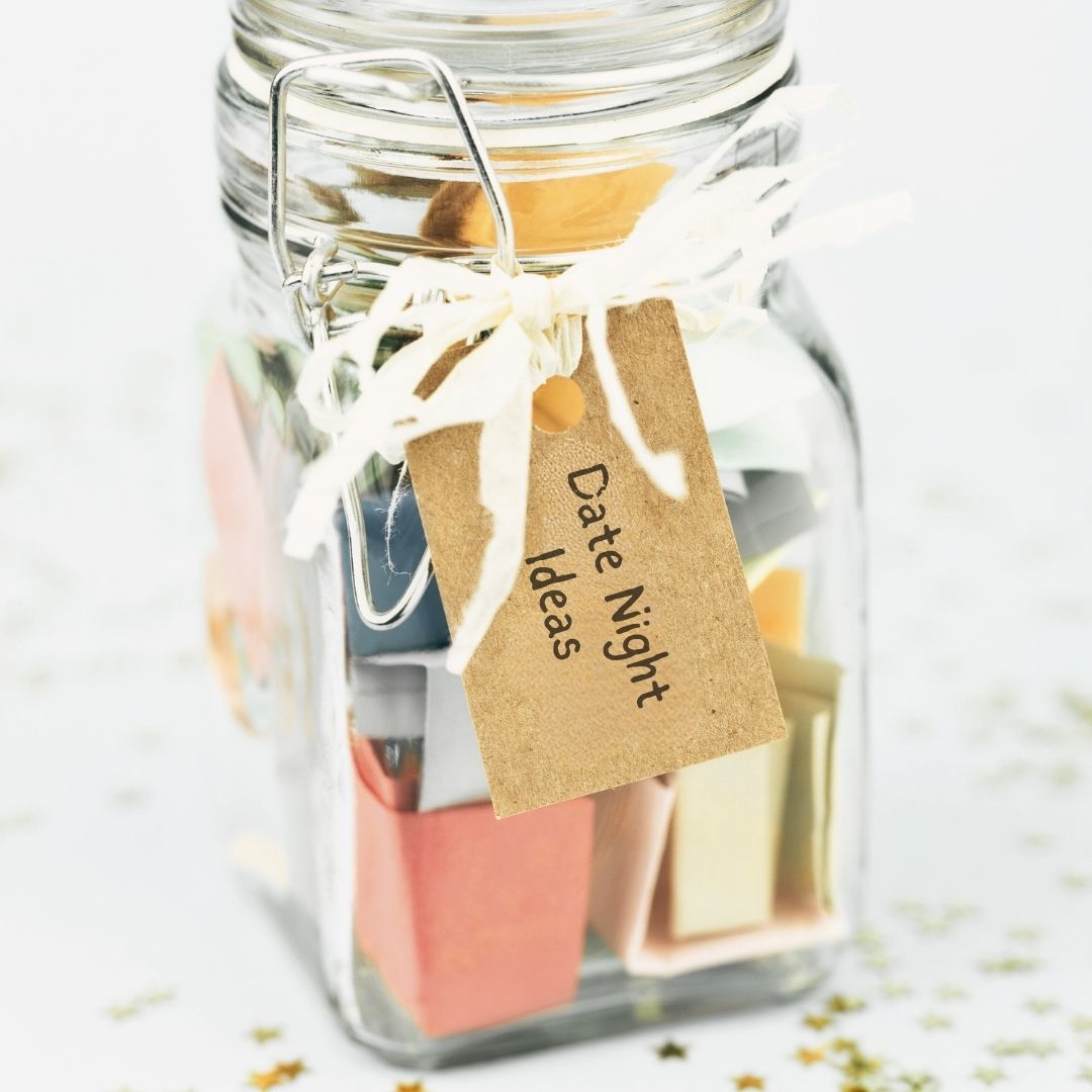 Clear jar with folded up piece of paper with date night ideas on them