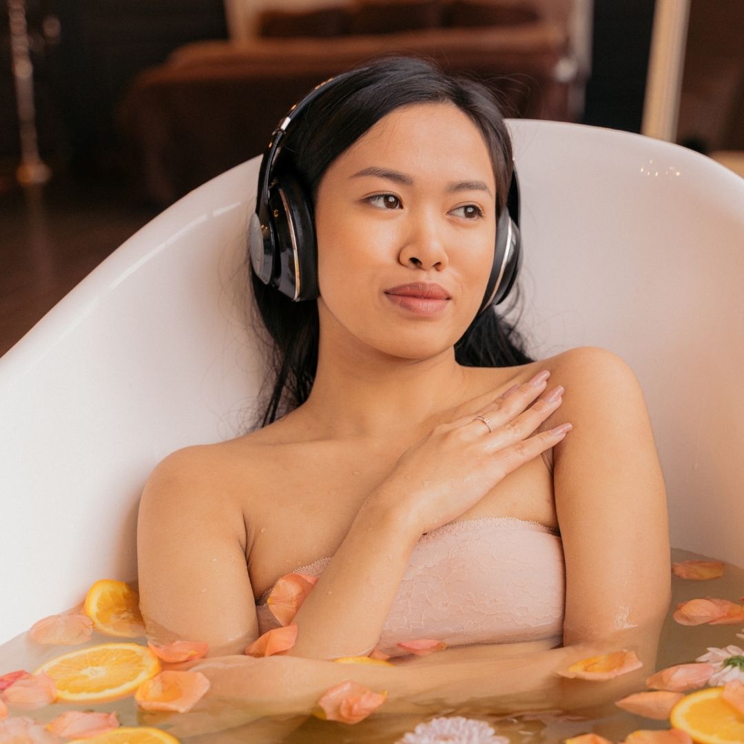 a girl in the bath with headphones on