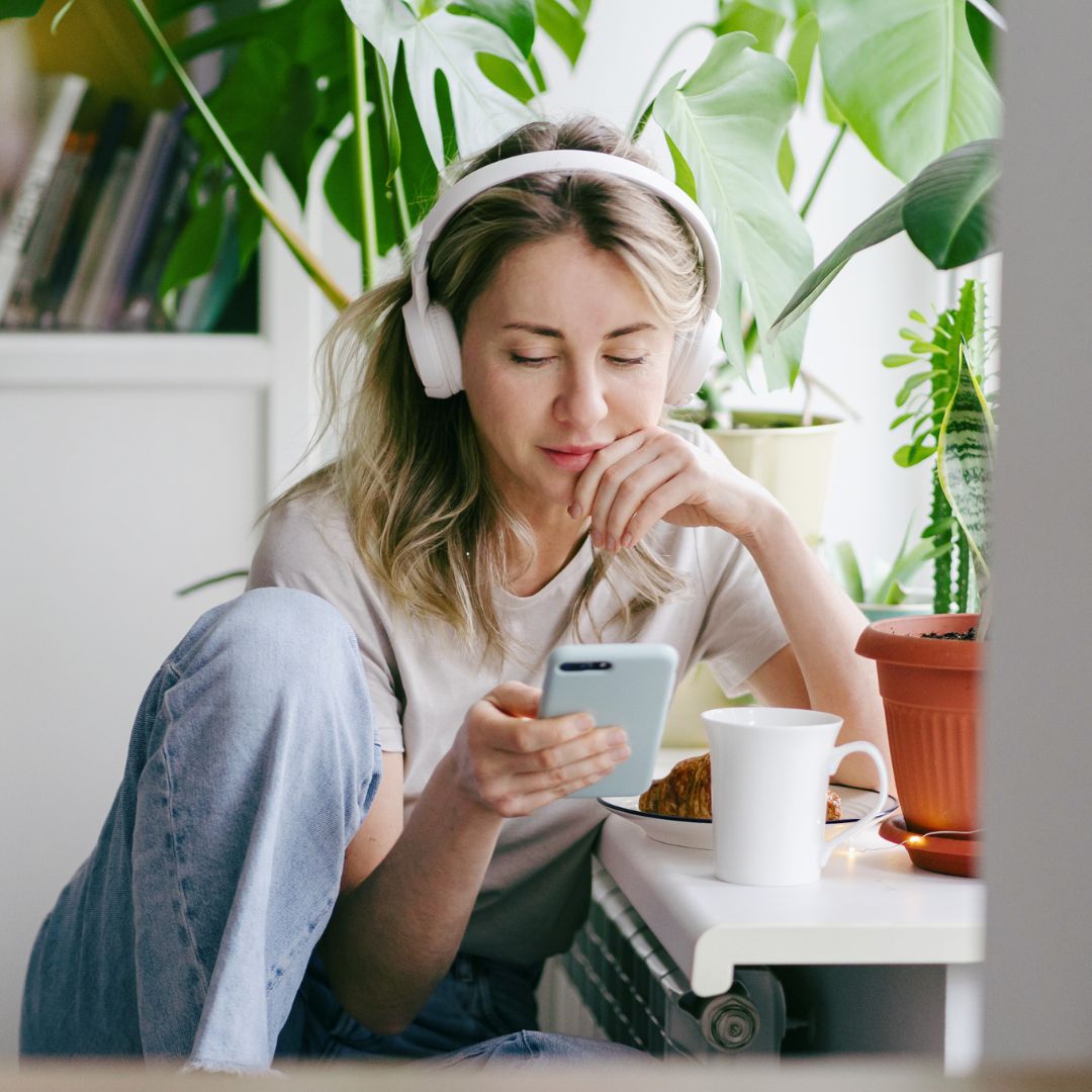 Woman with headphones listening to a podcast