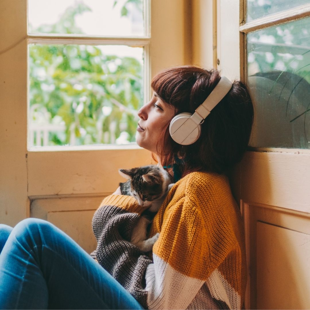 woman with headphones and cat