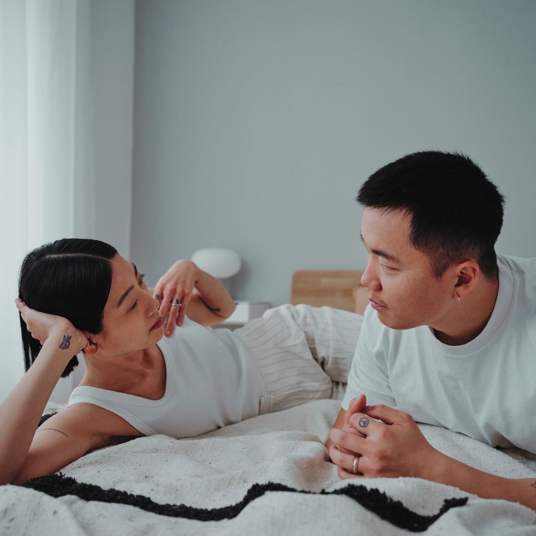 A couple lying on a bed having a deep conversation