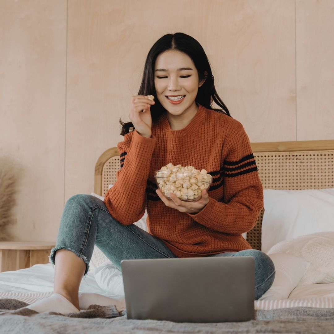 girl eating popcorn watching a show